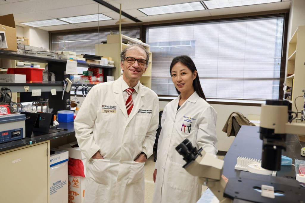 Kreisel and Terada wearing white coats in research laboratory